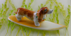 Hund auf dem Surfbrett, Porzelllanminiatur